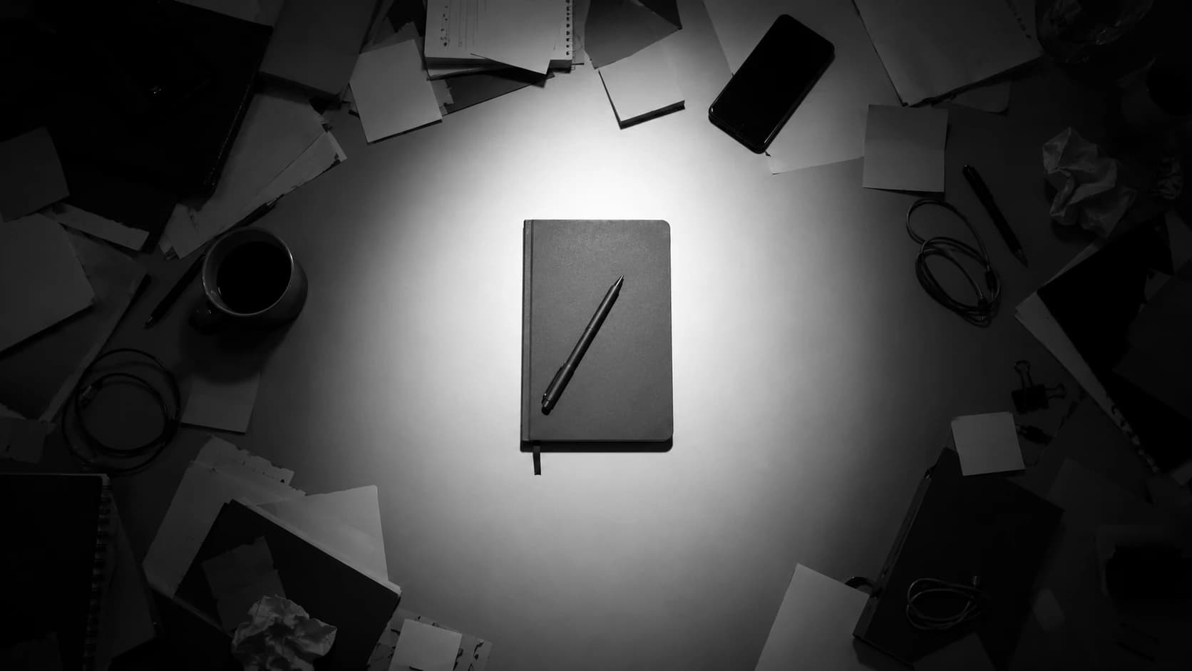 A desk seen from above with one task started and several unopened items pushed to the edges